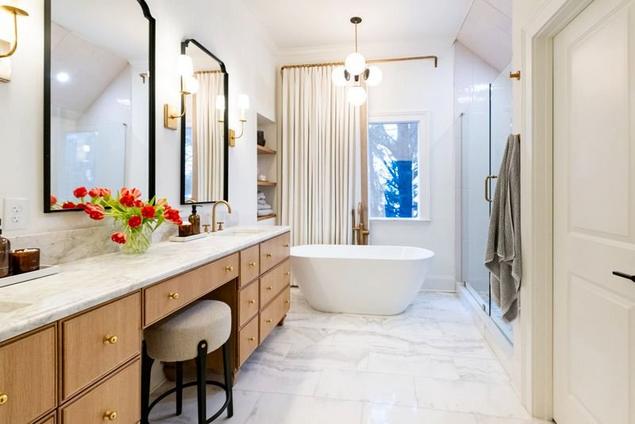Remodeled primary bathroom with white marble floors.